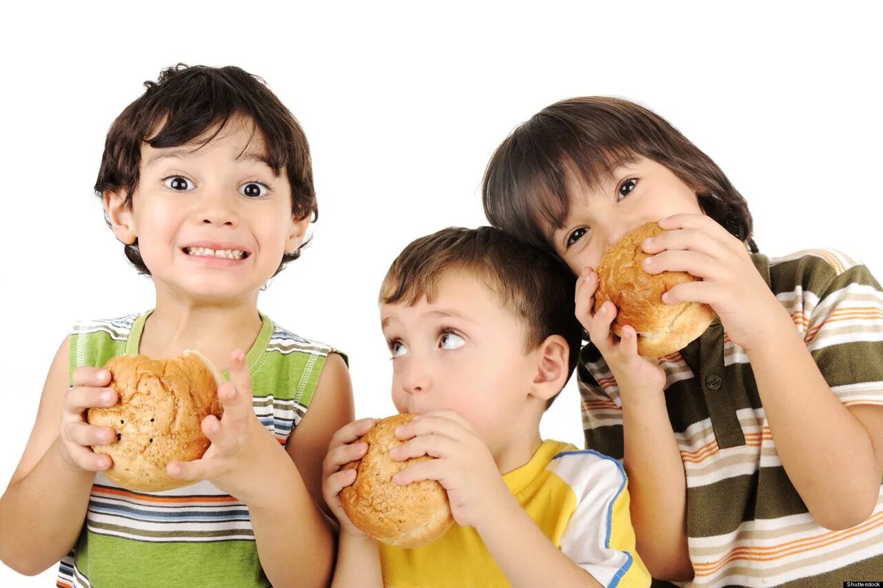 Человек есть хлеб. Дети и фаст фуд. Ребенок ест фаст фуд. Дети едят фаст фуд на столе. Фаст фуд картинки для детей.
