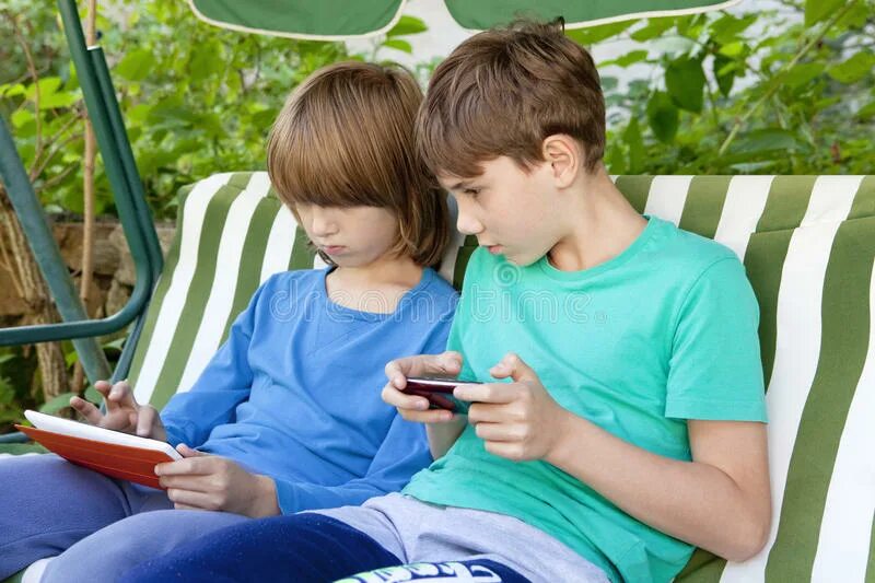 Мальчики имеют друг друга. A boy is sitting in the Garden. Boy sitting. A boy with a Tablet.