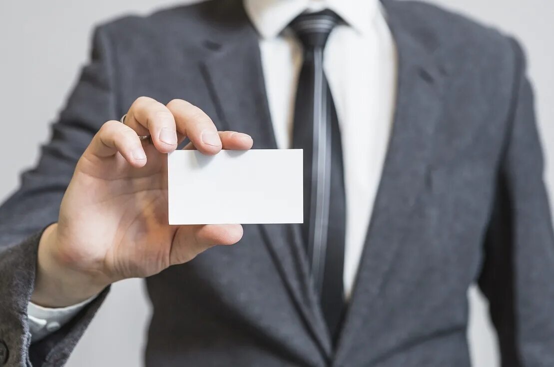 Бизнесмен держит карту. Телефон карточка бизнесмена. Человек с пластиковой картой. Мужчина протягивает визитку. Бизнесмен с карточкой.