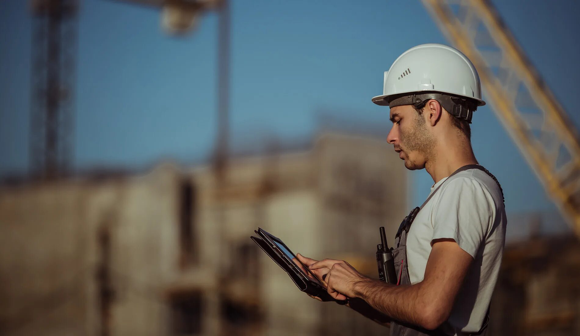 Workers load. Каска строителя. Люди в касках на стройке. Инженер Строитель. Строитель с планшетом на стройке.