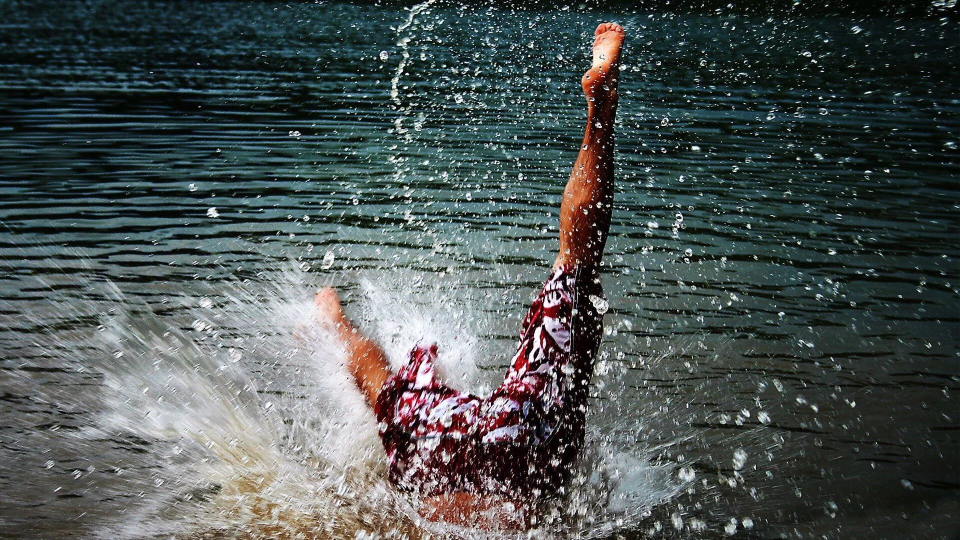 Девушка в брызгах воды. Человек, падающий втводу. Прыжок в реку. Ныряет в воду. Зарядка упала в воду