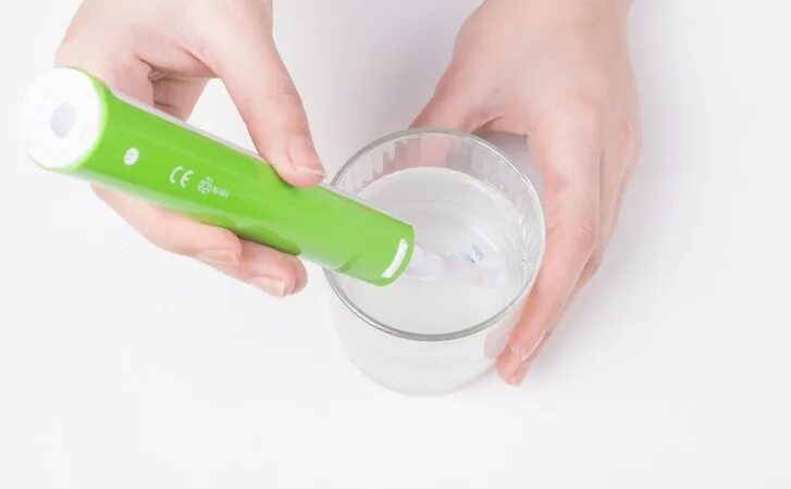 Как продезинфицировать зубную щетку. Жидкость. Как продезинфицировать зубную щетку. Зубная щетка на столе. Механическая зубная щетка.