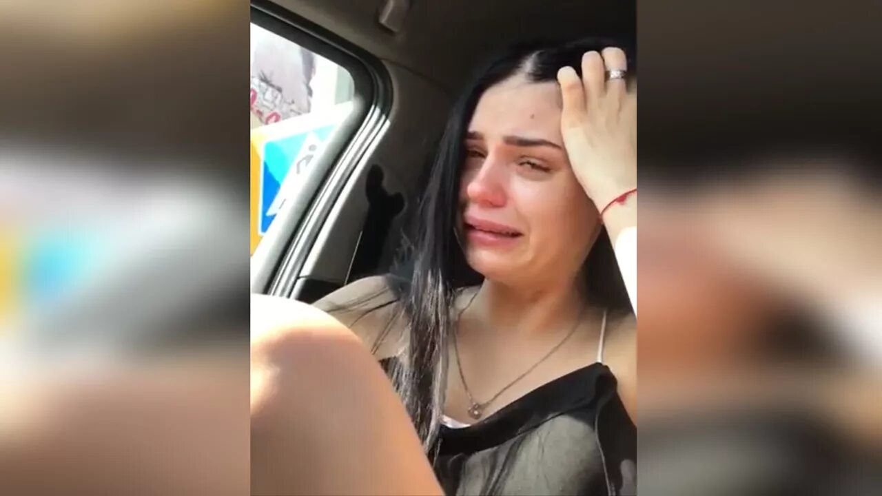 Девушка с айфоном плачет.