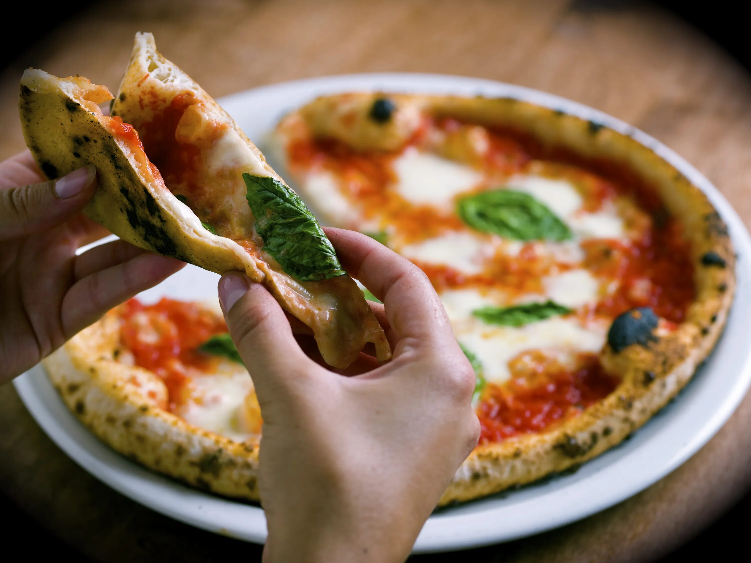 Пицца в руке. Итальянская пицца. Кусочек пиццы. Правильная итальянская пицца. Уномоменто пицца