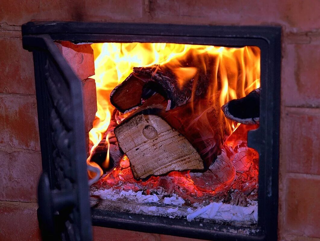 У теплой печки. Огонь в печке. Печь на дровах. Пламя в печке. Горящая печь.