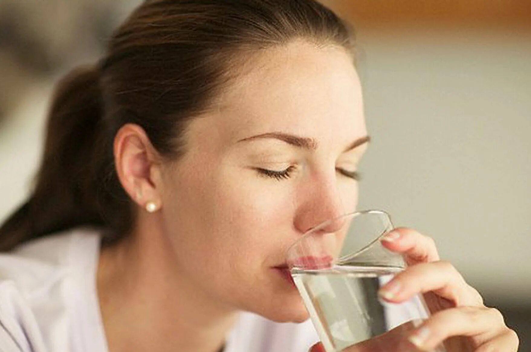 Девушка пьет воду. Обильное питье. Питье пациента. Женщина со стаканом воды.