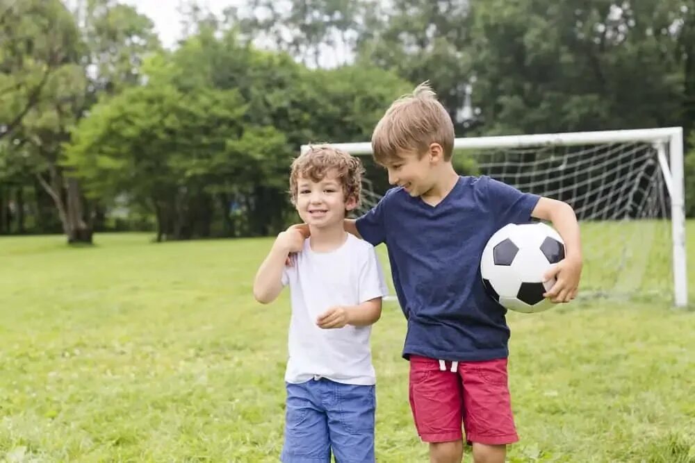 My brother plays football. Два мальчика с мячом. Два мальчика играют в футбол. Младший брат. Игра в футбол с братом.