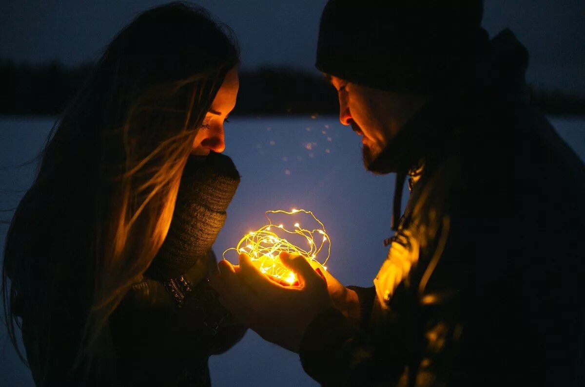 Семейный пара ночью. Колдовство любви. Магия любви. Влюбленные огоньки. Мужчина и женщина магия.