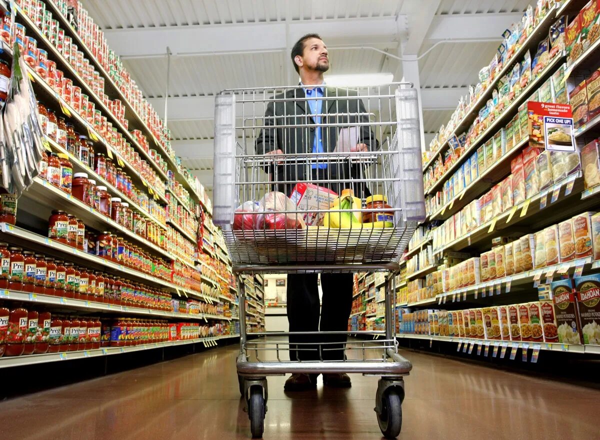 Человек прилавок. Супермаркет полки с продуктами. Люди с тележками в супермаркете. Полка супермаркета. Магазинная полка с продуктами.