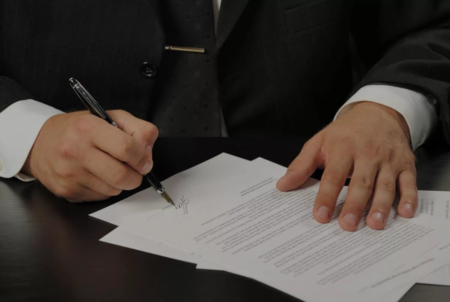 Подписание контракта. Человек подписывает документы. Заключение договора. Подпись документов. Человек подписывает бумаги.