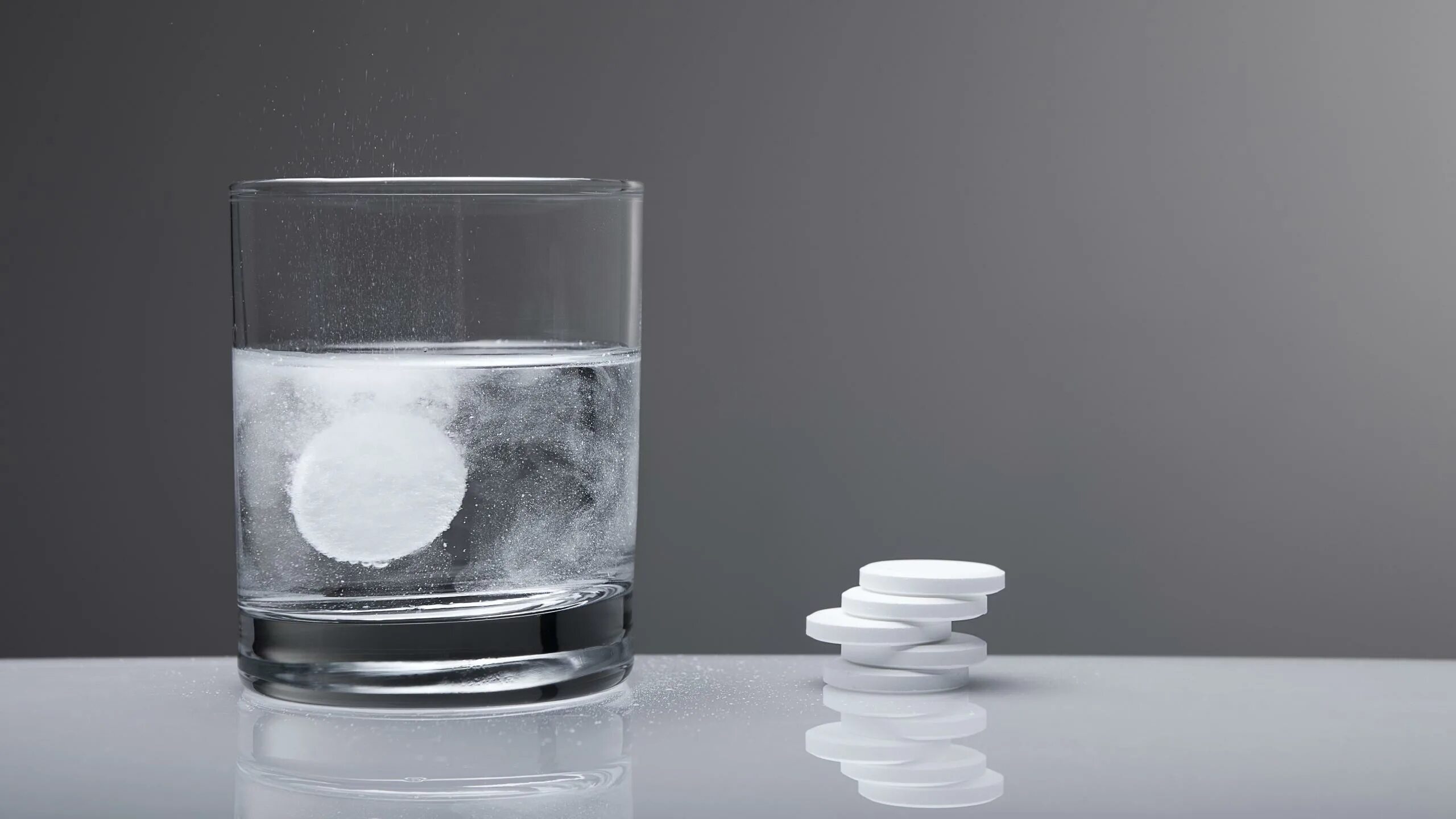 Растворение льда. Таблетки и стакан воды. Стакан воды. Шипучая таблетка в стакане воды. Таблетка растворяется в воде.