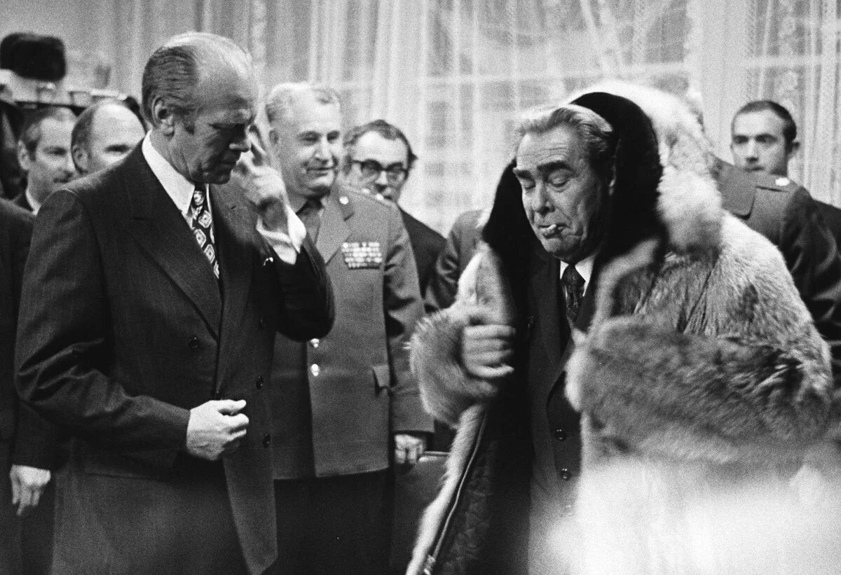 Брежнев 1974. Брежнев в шубе перед президентом США. Брежнев в шубе и с сигаретой перед президентом США. Американский брежнев