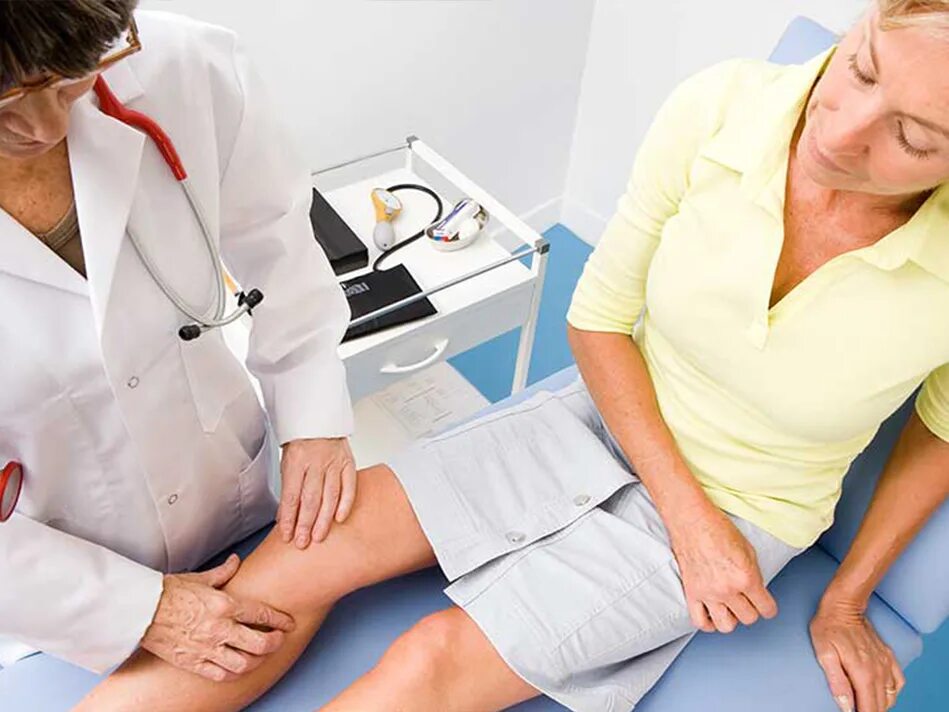 Стационарное обследование и лечение. Врач осматривает колено. Врач с больным пациентом с коленом. Врач осматривает пациента с больными суставами.