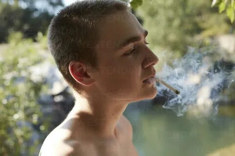 Portrait of teenage boy smoking cigarette in nature - AMEF00013 - Antje.