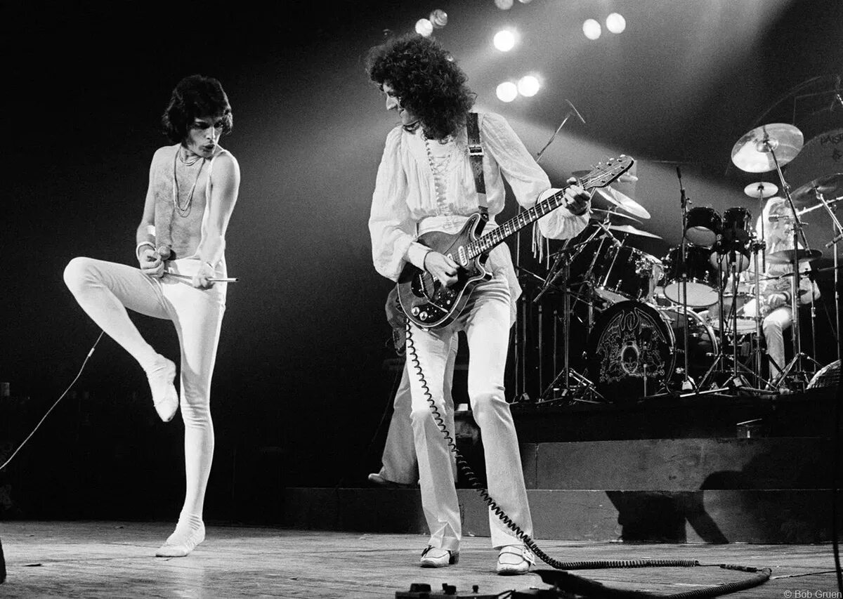 Queen 1977. Фредди Меркьюри группа в 80х. Боб Груэн. Фредди Меркьюри в 1977 году.