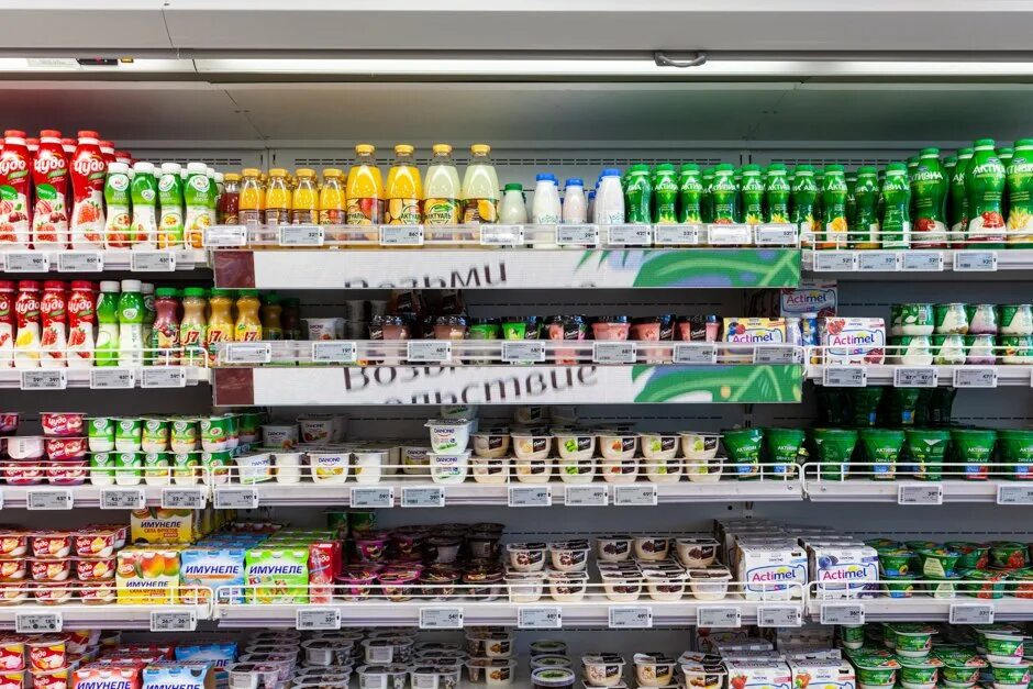 Молочная продукция на полках. Полки супермаркета. Ассортимент n. Магнит внутри. Консервы на прилавке.