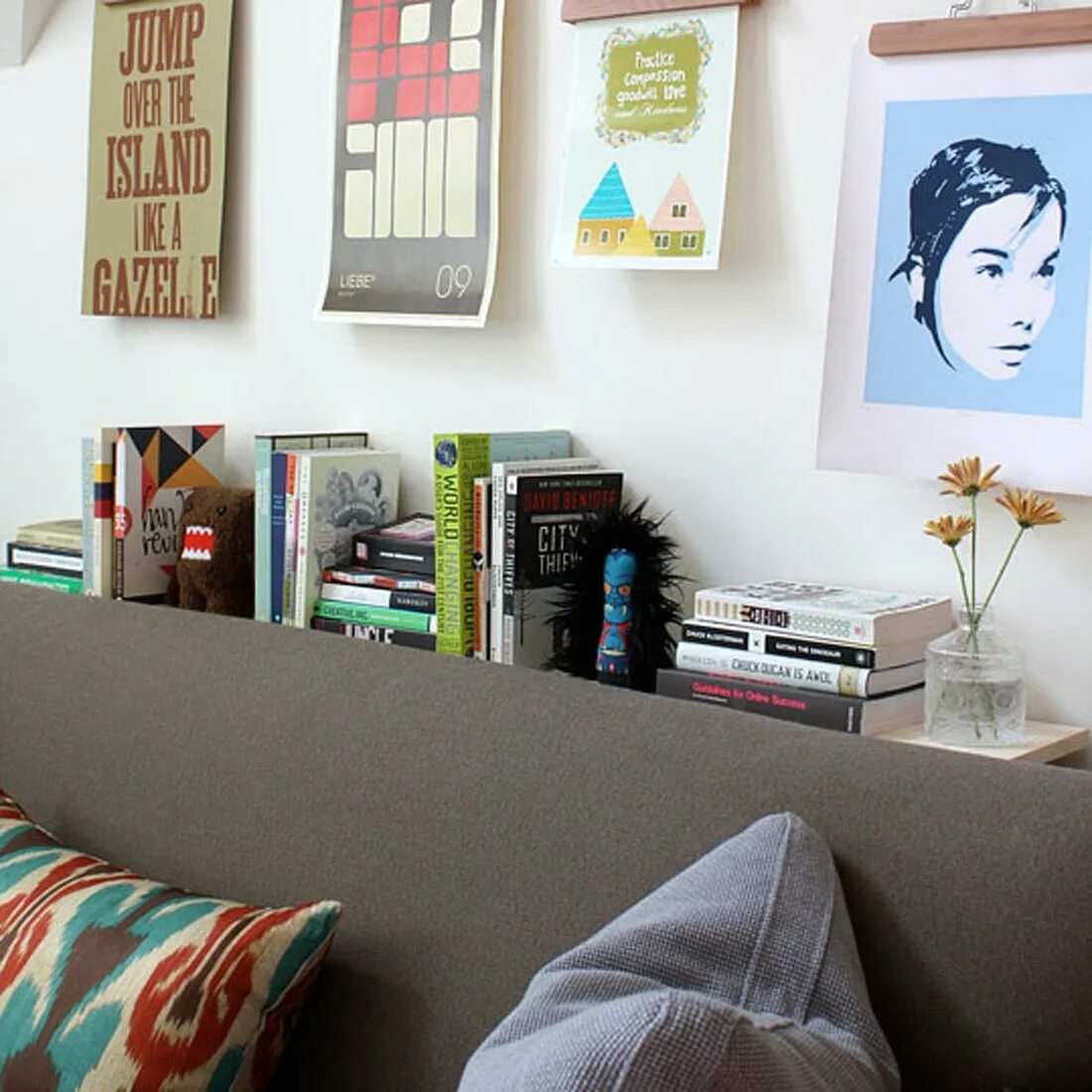 Вешает плакат на стену. Приклеить картину на стену. Как не испортить обои плакатами. Как не испортить обои плакатами. На что приклеить фотографии на стену.