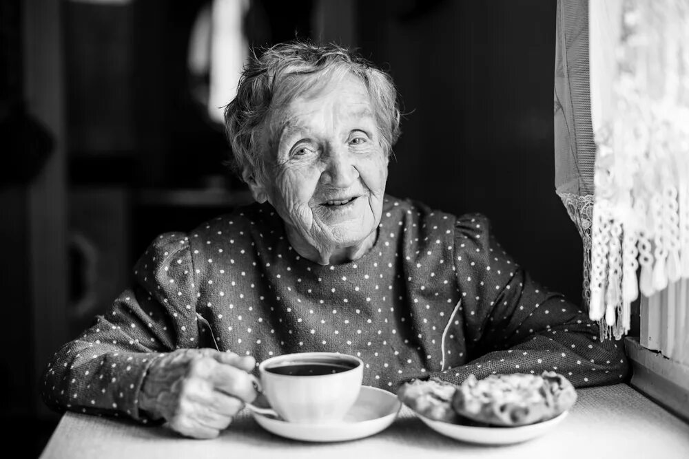 Пожилая женщина за столом. Пожилые люди улыбаются. Пожилая женщина чай. Бабушка с чашкой чая. Бабушки любят погорячей