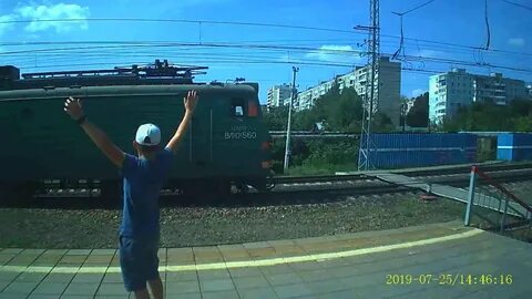 Электровоз с грузовым поездом приветливый машинист
