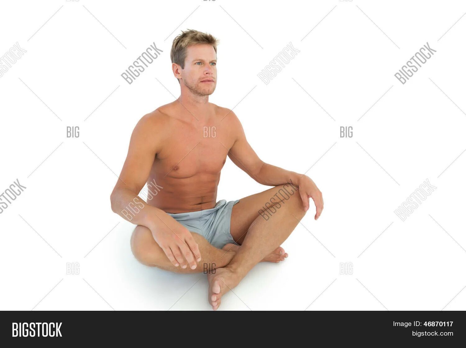 Мужчина сидит в позе лотоса. Парень сидит по турецки. Человек сидит скрестив ноги. Поза лотоса вид с боку.