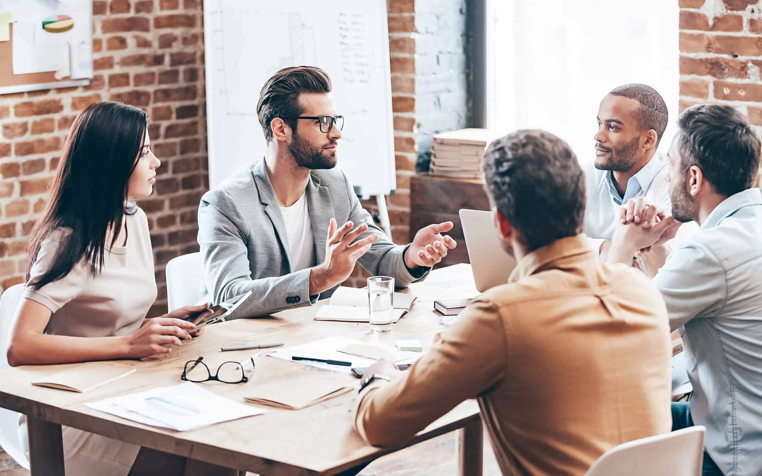 Организация бизнеса. Командная работа. Переговорная с людьми. Группа людей за столом. Менеджмент.