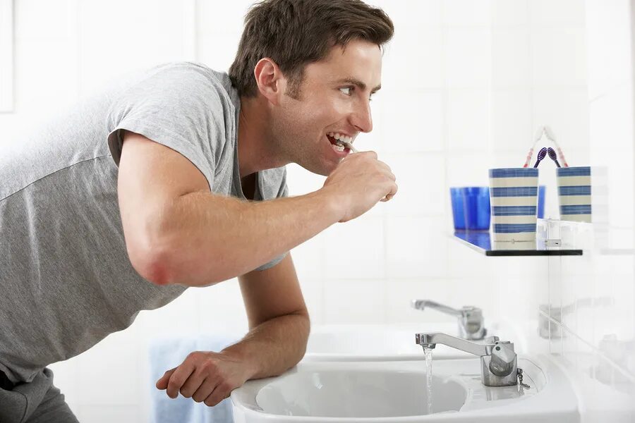 Выключи воду в ванной. Человек над раковиной. Выключайте воду когда чистите зубы. Мужчина чистит ванну. Человек чистит зубы в ванной.