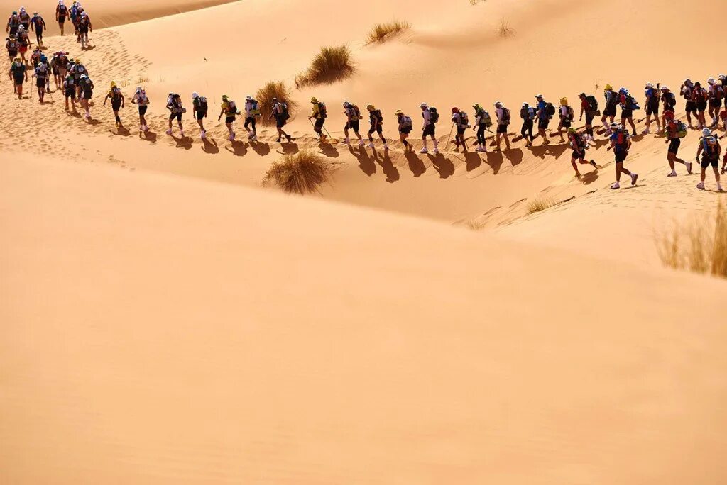 Пустынные бега. Негр в пустыне. Марш в пустыне. Идущие по пустыне. Толпа людей в пустыне.