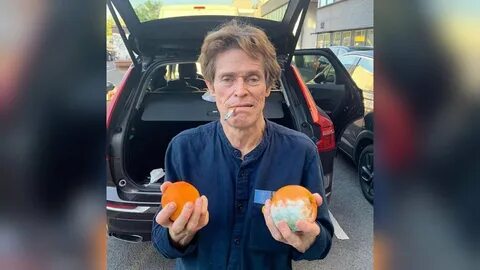 Willem Dafoe Smoking Cigarette With Two Oranges One of Them 