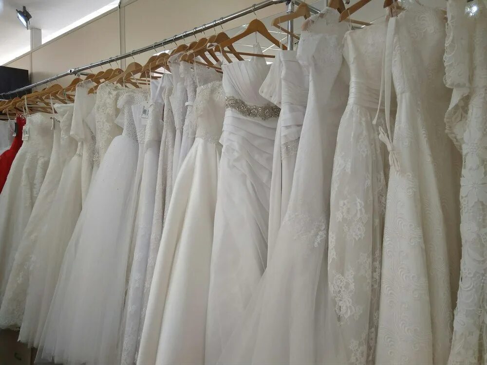 Куплю платье бу. Свадебное платье на вешалке. Свадебные платья на вешалках в салоне. Платья на свадьбу на вешалки. Много свадебных платьев.