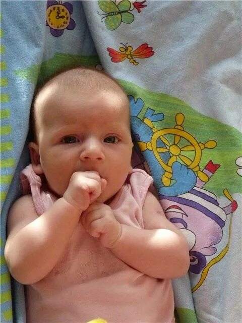 Грудничок обсосал палец. Грудничок высовывает язык. Ребенок 3 месяца жует кулак. Ротик 3 месячного ребенка. Ребенок 3 месяца жует кулак.