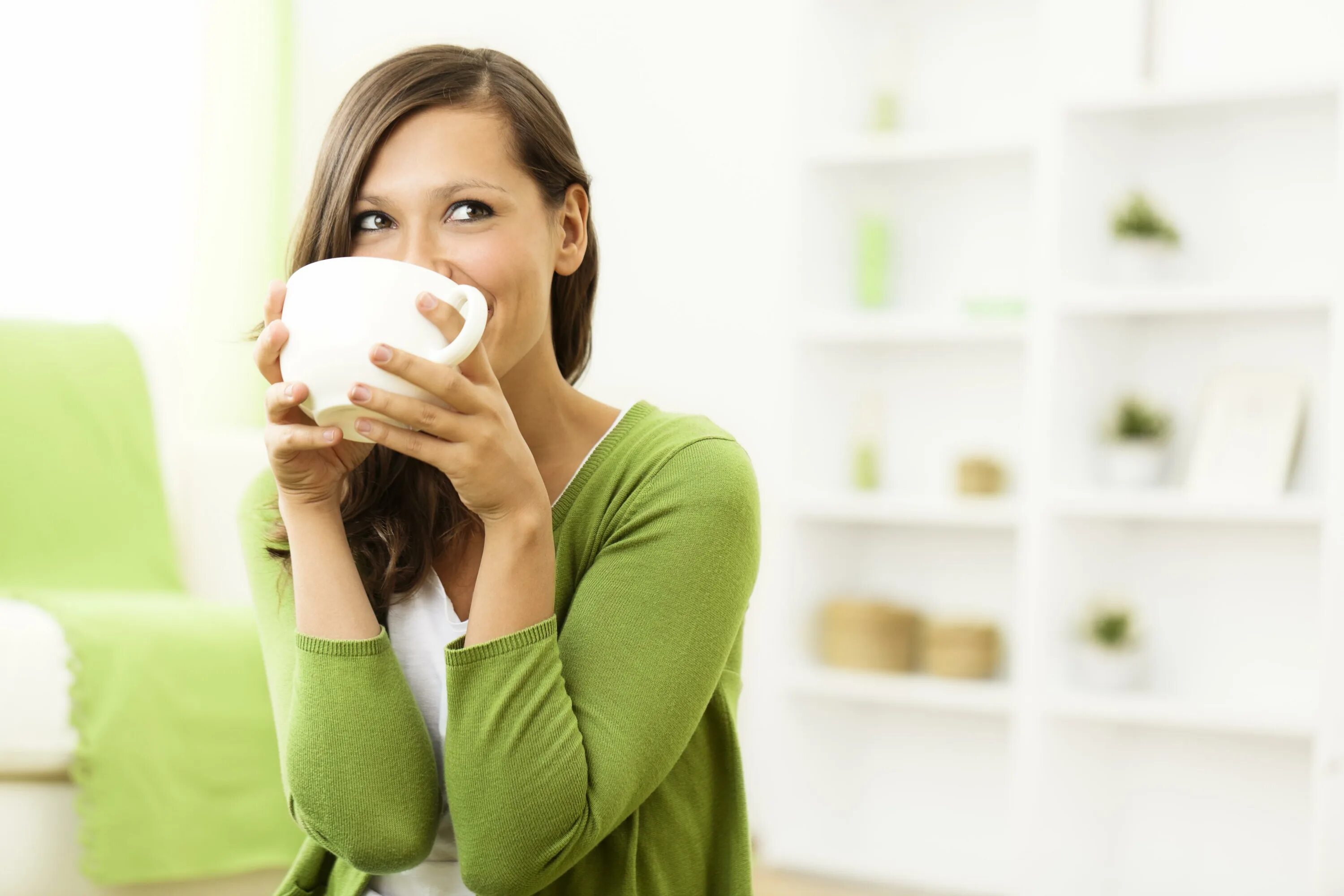 Женщина принимает на дому. Девушка пьет чай. Девушка пьет зеленый чай. Женщина с чашкой чая. Довольная женщина.