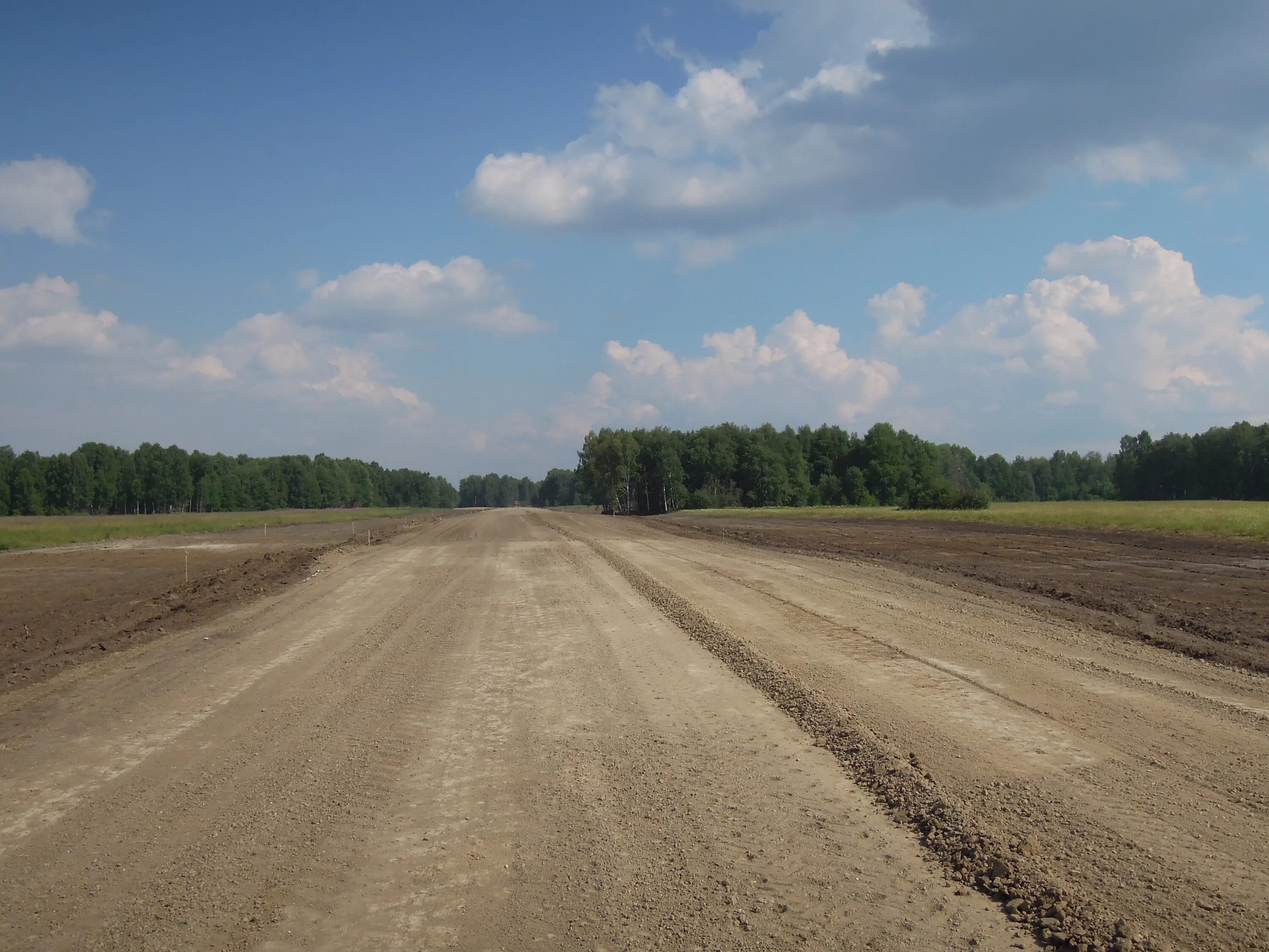 грунтовая автомобильная дорога. возведение земляного полотна. дорожно земляные. песчаные дороги. проселочная дорога сбоку.