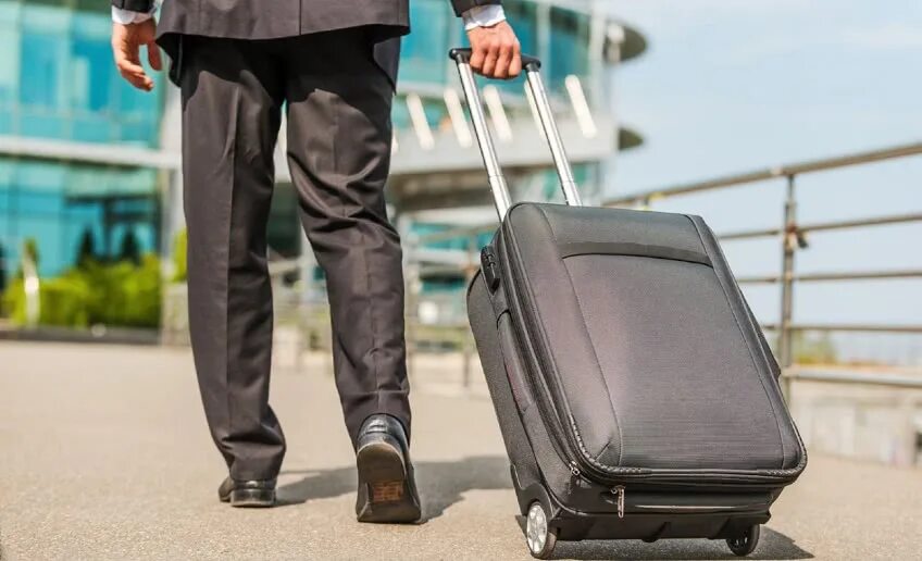 Мужчина с чемоданом в аэропорту. Командировка. Командировка. Заграничные командировки. Командировка работника.