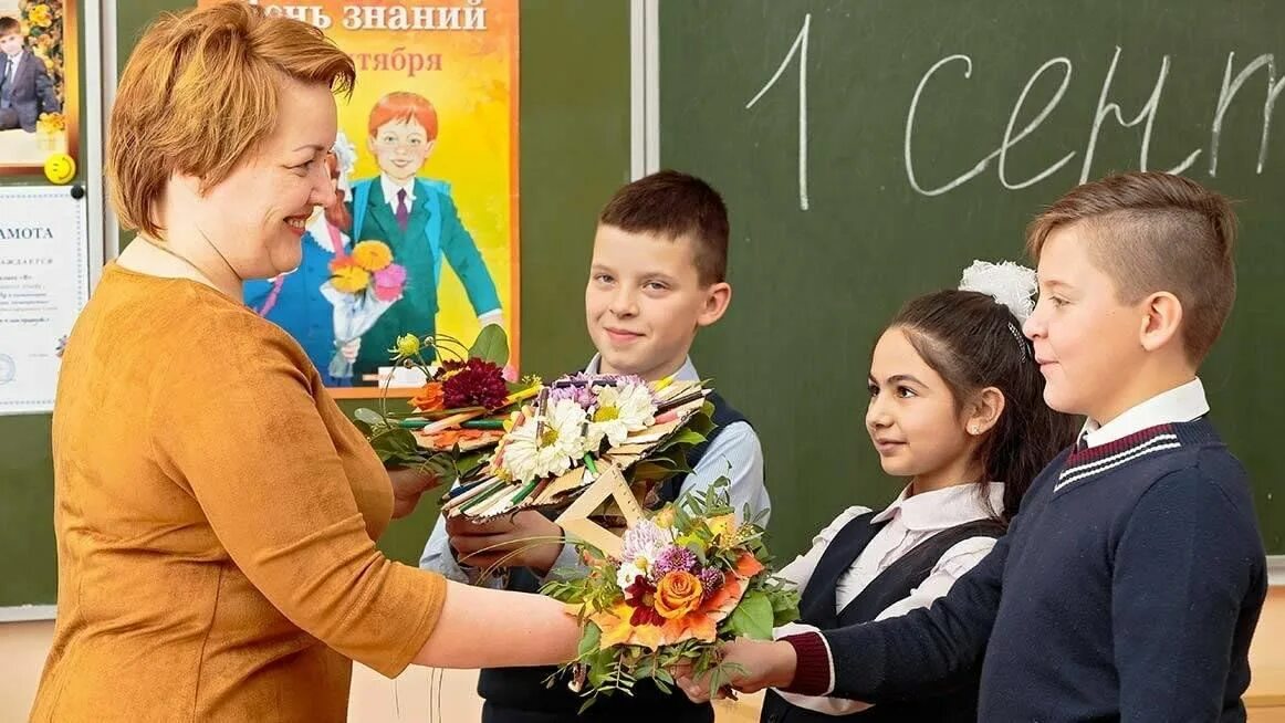 Как проводят день учителя в школах. Учительница и первоклассник. Учительница с первоклашками. Учитель встречает детей в школе. С 1 сентября учителю