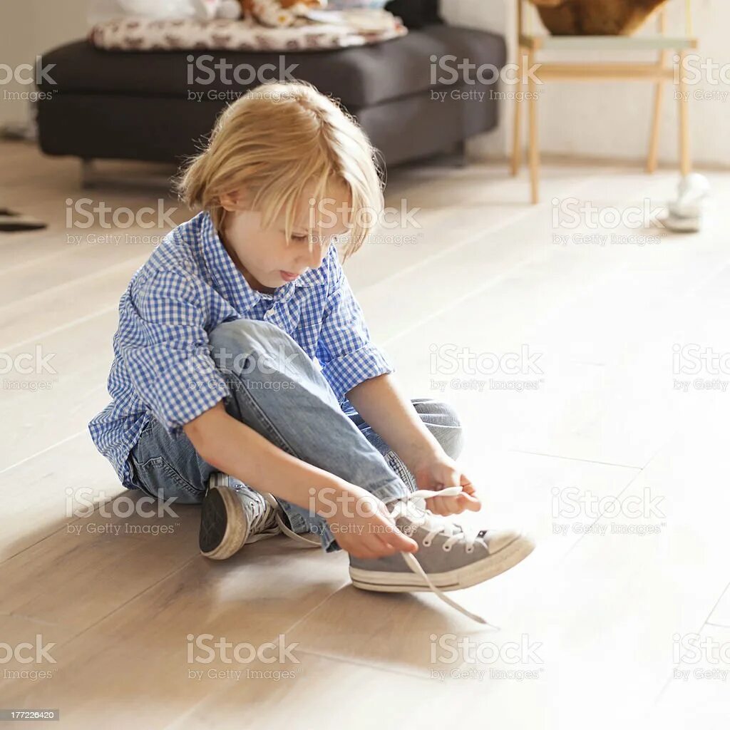 Мальчик обувается. Ребенок завязывает шнурки. Дети на полу обуваются. Неторопливый ребенок. Медленно одевается