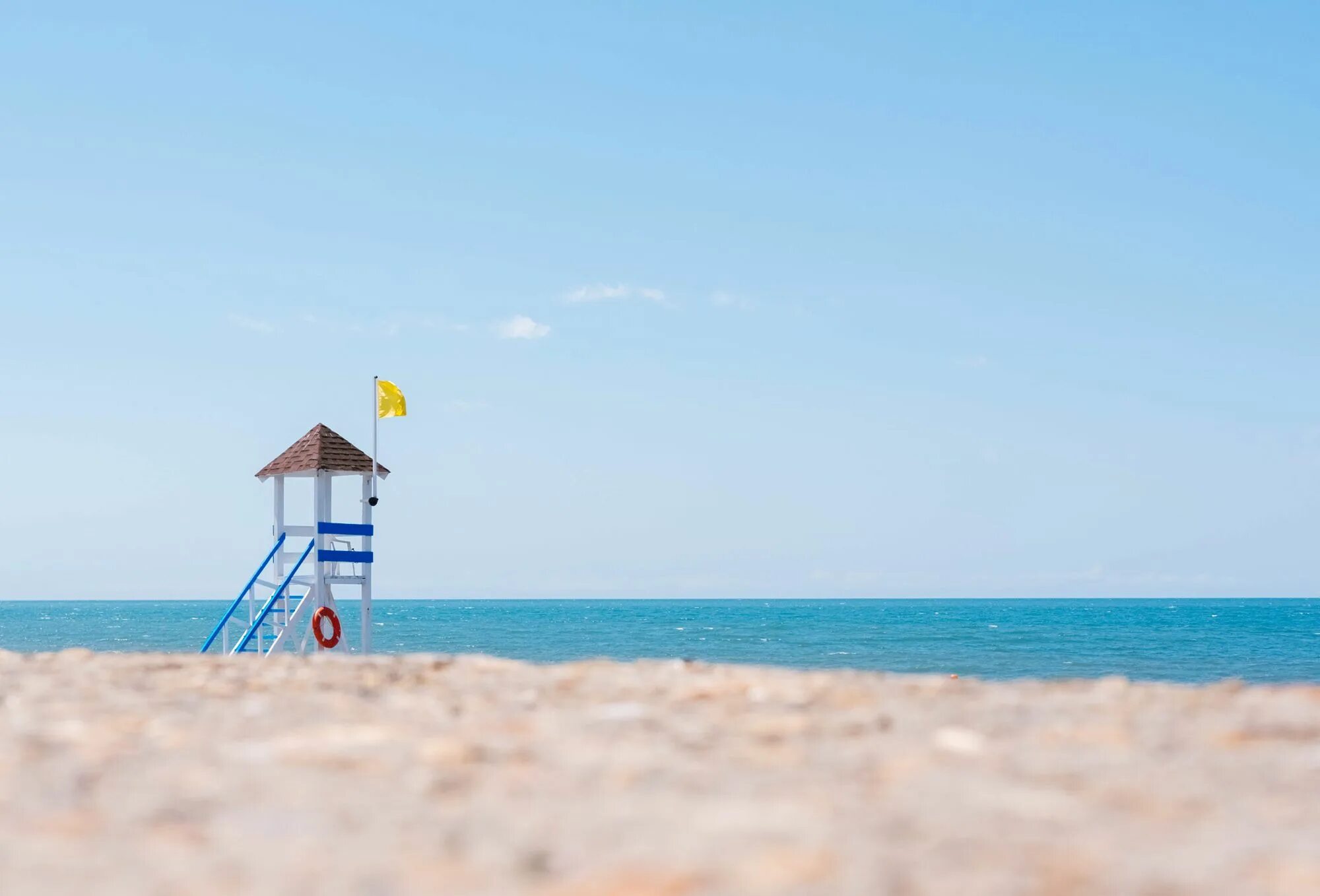 Лето. Отдых на черном море. Спасательная вышка на пляже. Флаги на спасательной вышке на пляже. During vacation