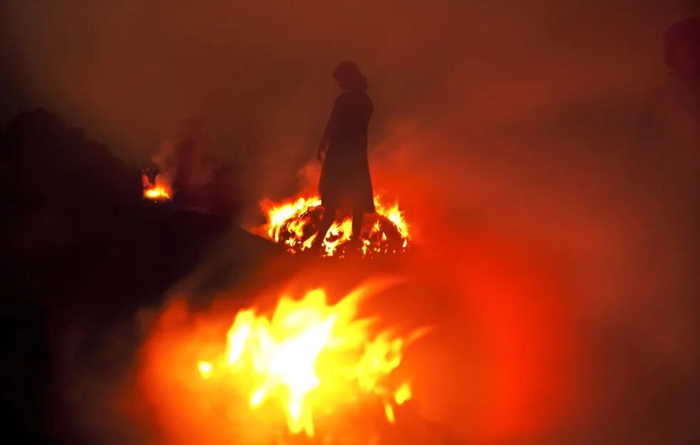 горящие деревья. огонь ведьмы. мужчина у костра. огонь на черном фоне. ладони у костра.