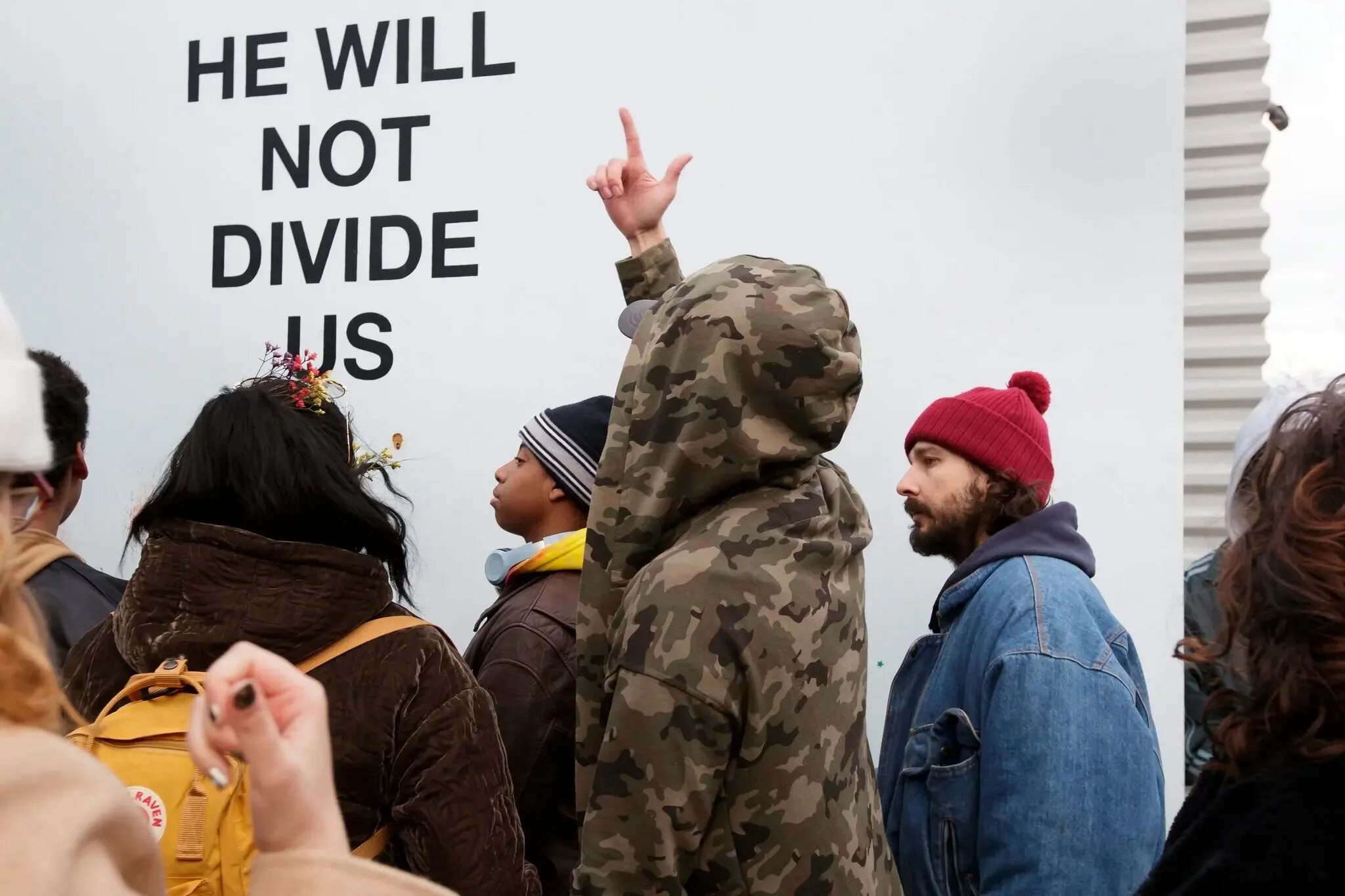 He will not divide us что значит. Шайа лабаф против трампа. he will not divide us. шаелабаф и трамп. шайла баф флаг с надписью против трампа.