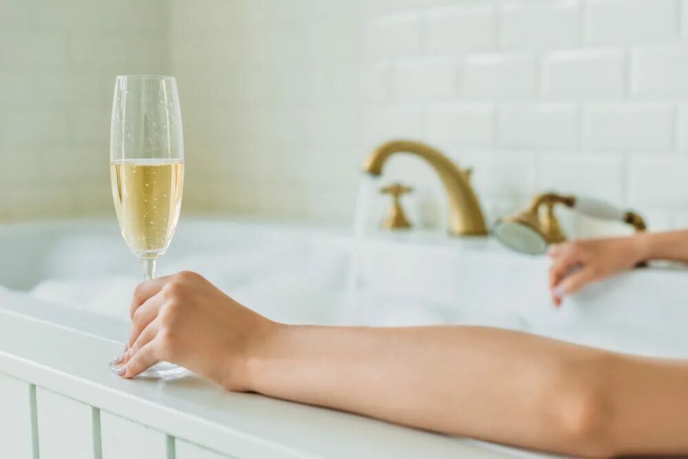 Ванна с шампанским. Девушка в ванной с бокалом вина. Бокал шампанского в ванной.