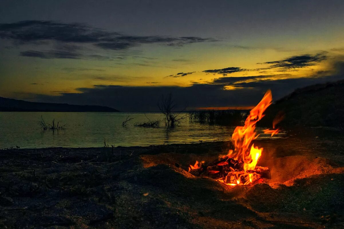 Горит закат. Костер у реки. Костер на берегу моря. Костер на закате. Костер на берегу реки ночью.