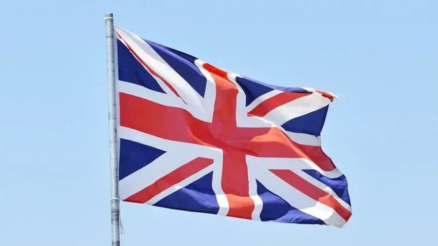 Флаг Великобритании. Британский флаг развевается на ветру. Развевающийся флаг Великобритании. Флаг Великобритании фото. В англии спустили флаг