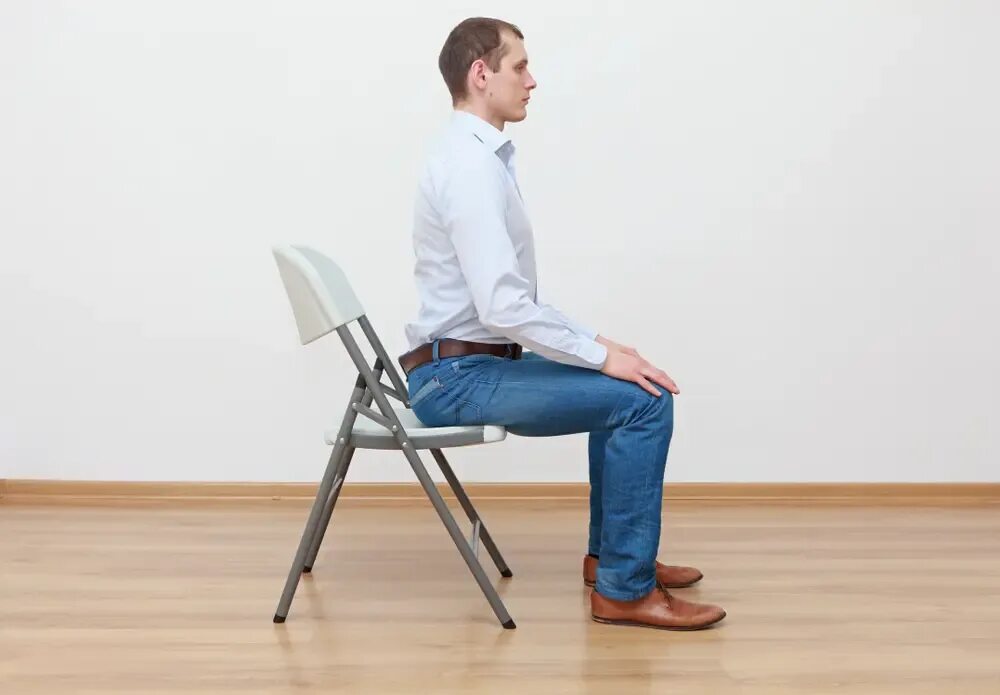 Горящий стул. Men on Edge Chair. A man sitting with a straight back. Sitting position on the Edge of the Chair.