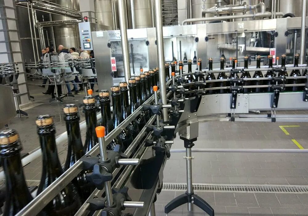 Газированная машина. Женщина на линии розлива газированных напитков. Холодный розлив. Асептическое наполнение флаконов. Триблок розлива стандарт плюс.