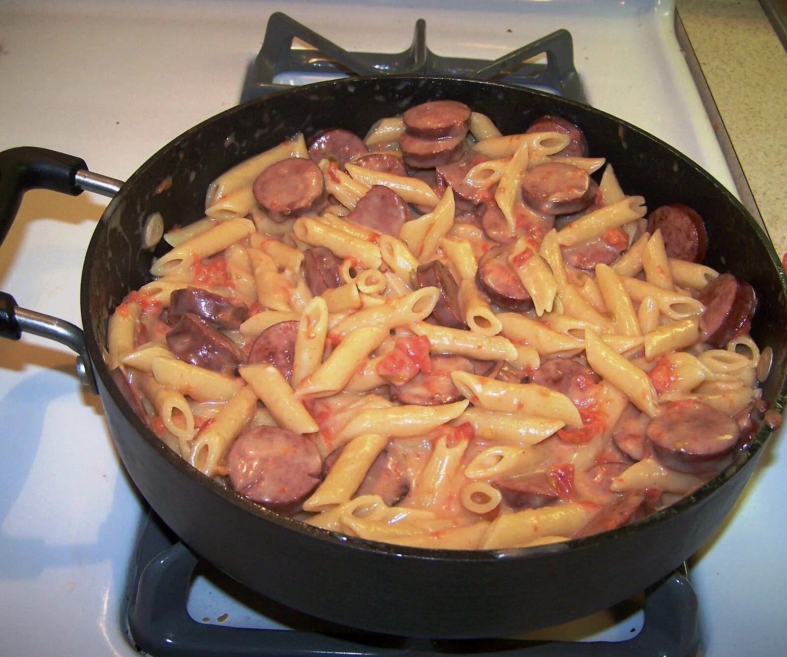 Макароны с колбасой и луком на сковороде. Макароны с сосисками на сковороде. жареные макароны с сосисками. жареные макароны с сардельками. макароны с сардельками на сковороде.