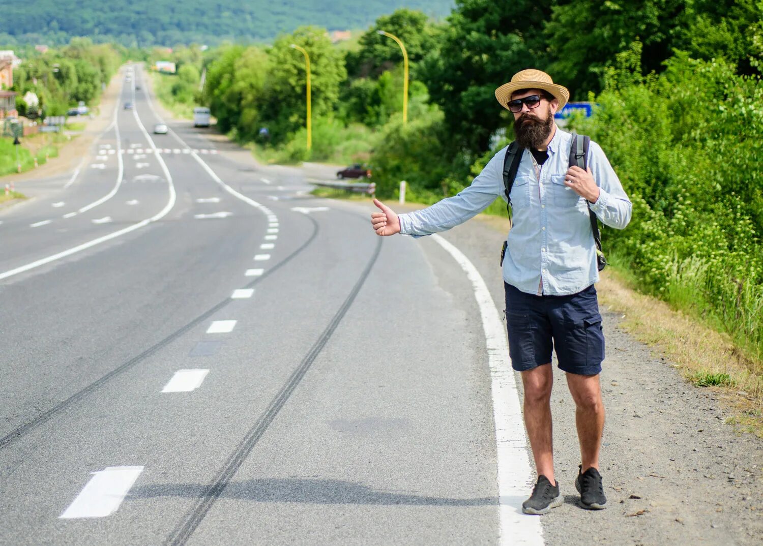 S way travel. Автостопом. Путешественник на дороге. Автостопщик с табличкой. Человек останавливает машину.