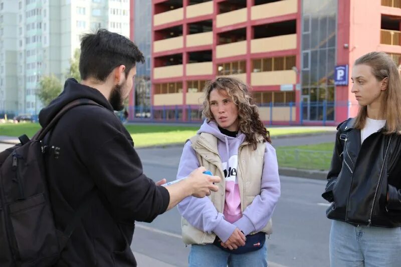 спб волонтеры в синих плащах с якорем и радужными флагами. волонтёры петродворцового района. диалог медработники. парни студенты волонтеры. познакомились в колледже.