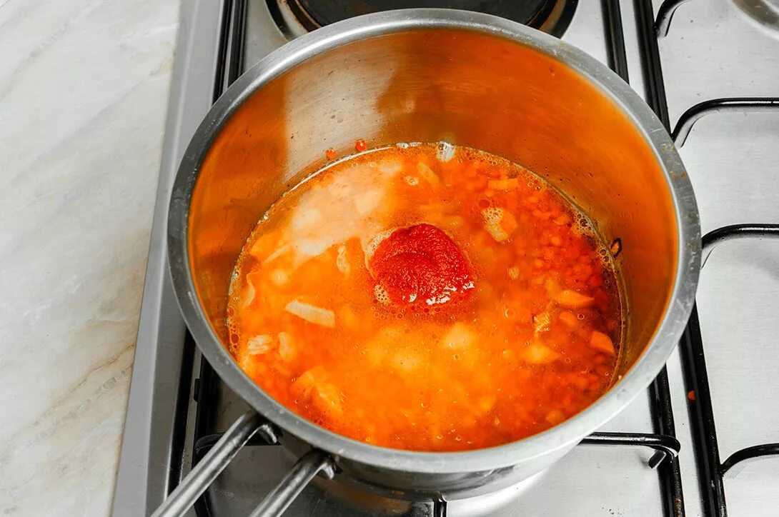 Кипят до готовности. Пассерование томатного пюре. Суп в кастрюле. Добавляют пассерованные с томатным пюре овощи. Кипящий суп.