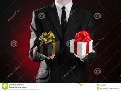 Праздники и подарки темы: человек в черном костюме держа подарок 2 исключений уп