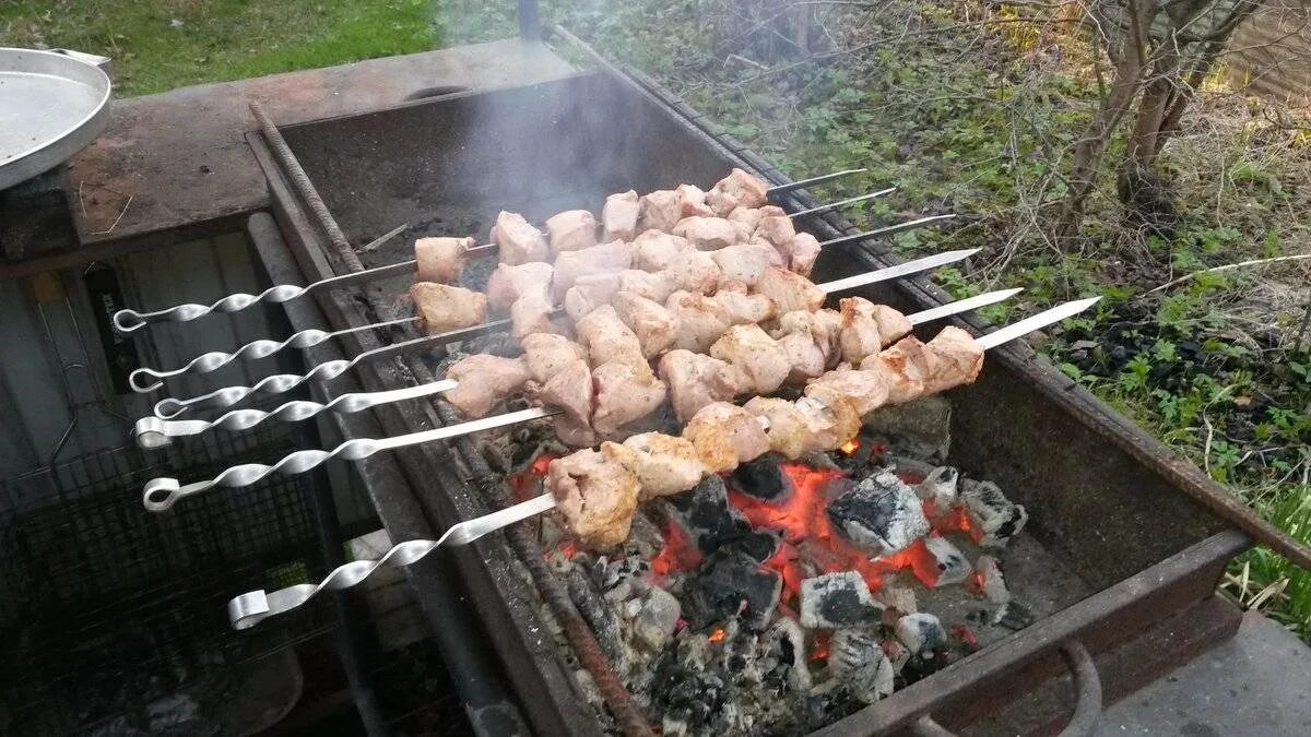Шашлыки во дворе жилого дома. Шашлыки на даче. шашлык на мангале. дачный шашлык. шашлыки в загородном доме.