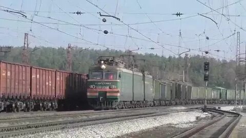 Электровоз с грузовым поездом приветливый машинист